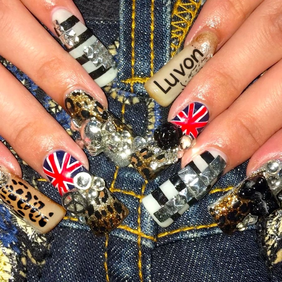 Elaborate nail art in leopard print, checkerboard, rhinestones, and a hand-lettered 'Luvon' nail, over a denim backdrop.
